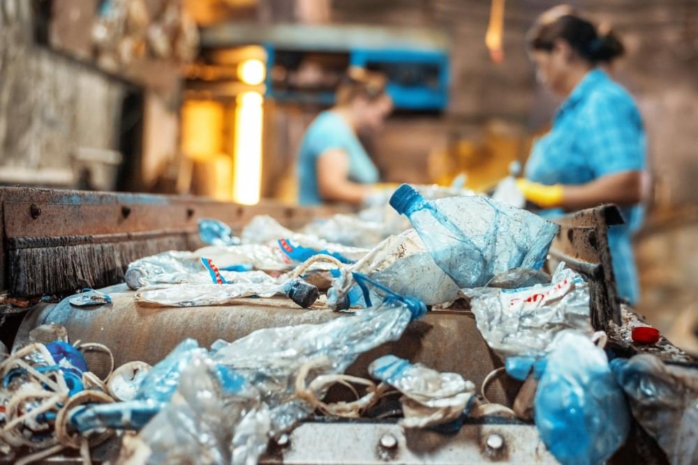 Two women working together in a factory, focusing on plastic bottles for Clean Out Service in Aurora, CO.