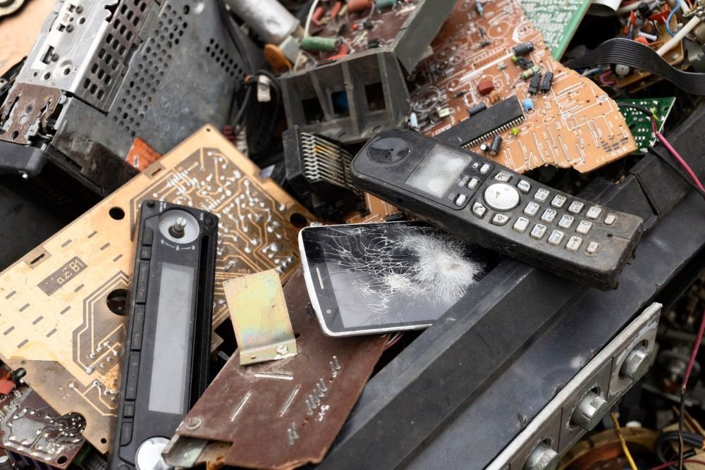 A stack of old electronics and cell phones, symbolizing e-waste for a junk removal service based in Aurora, CO.