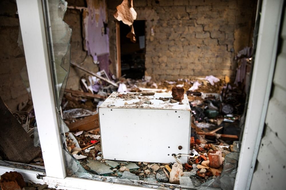 A refrigerator in a room cluttered with debris, illustrating the indoor junk removal service in Aurora, CO.